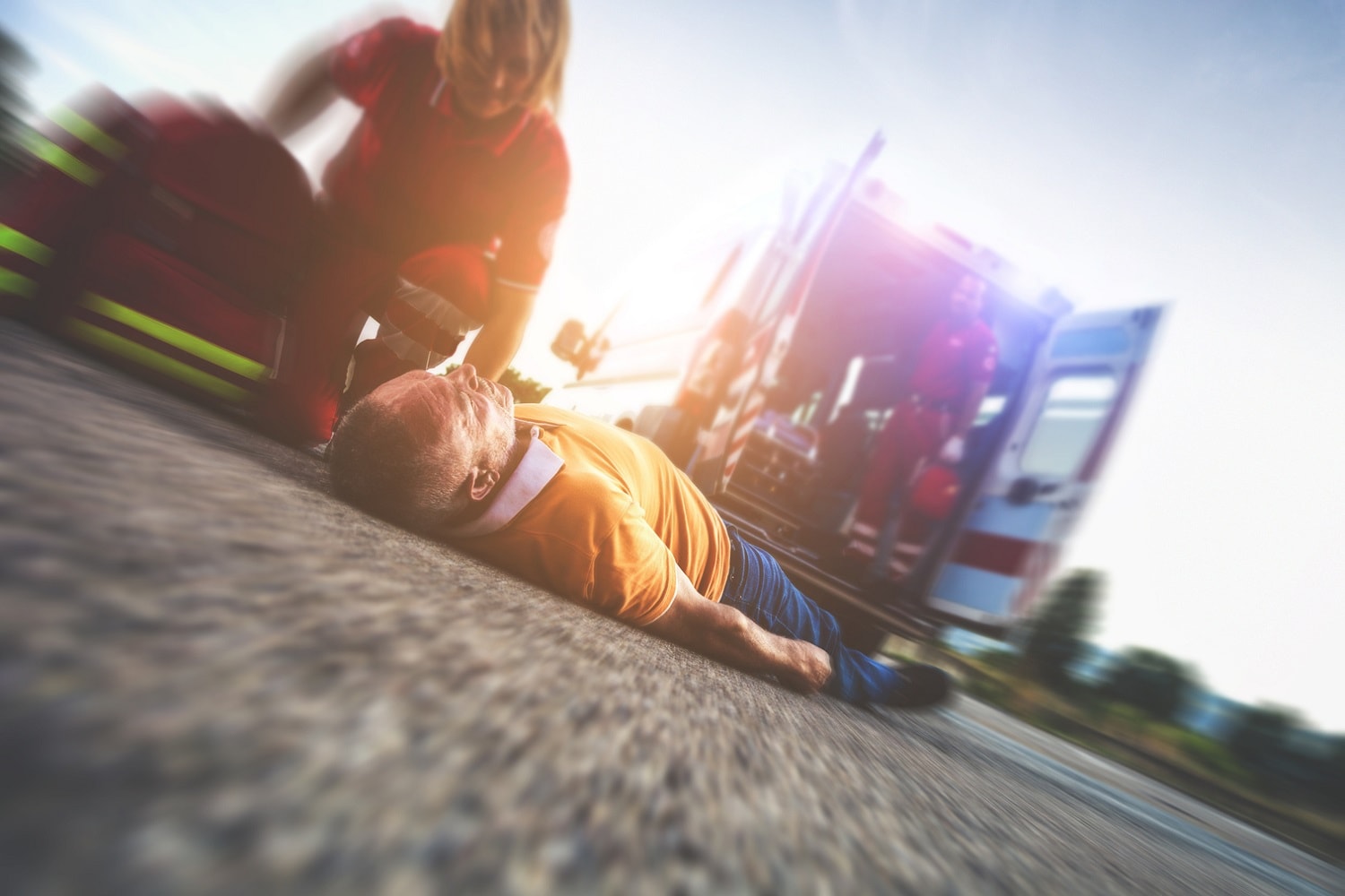 firewoman helping man laying down after an accident